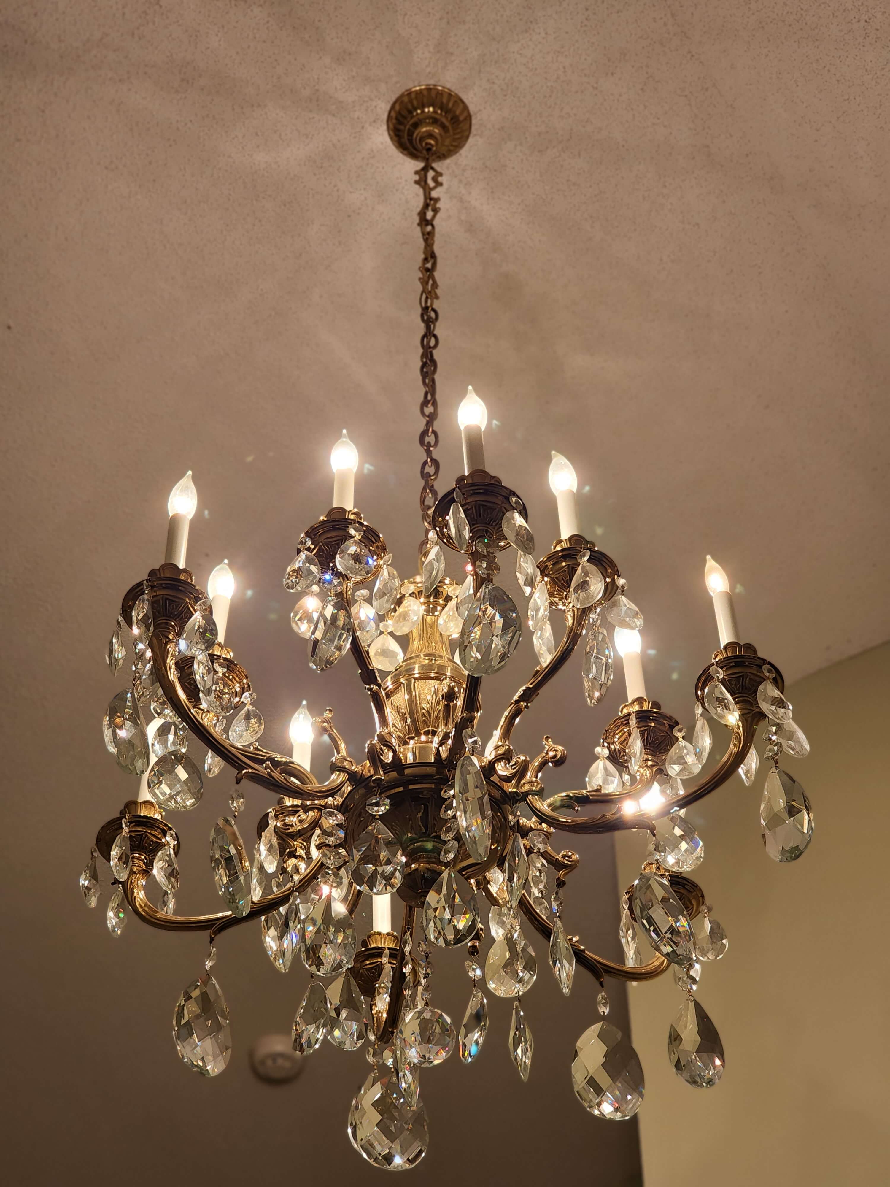 Traditional brass and crystal chandelier installation
