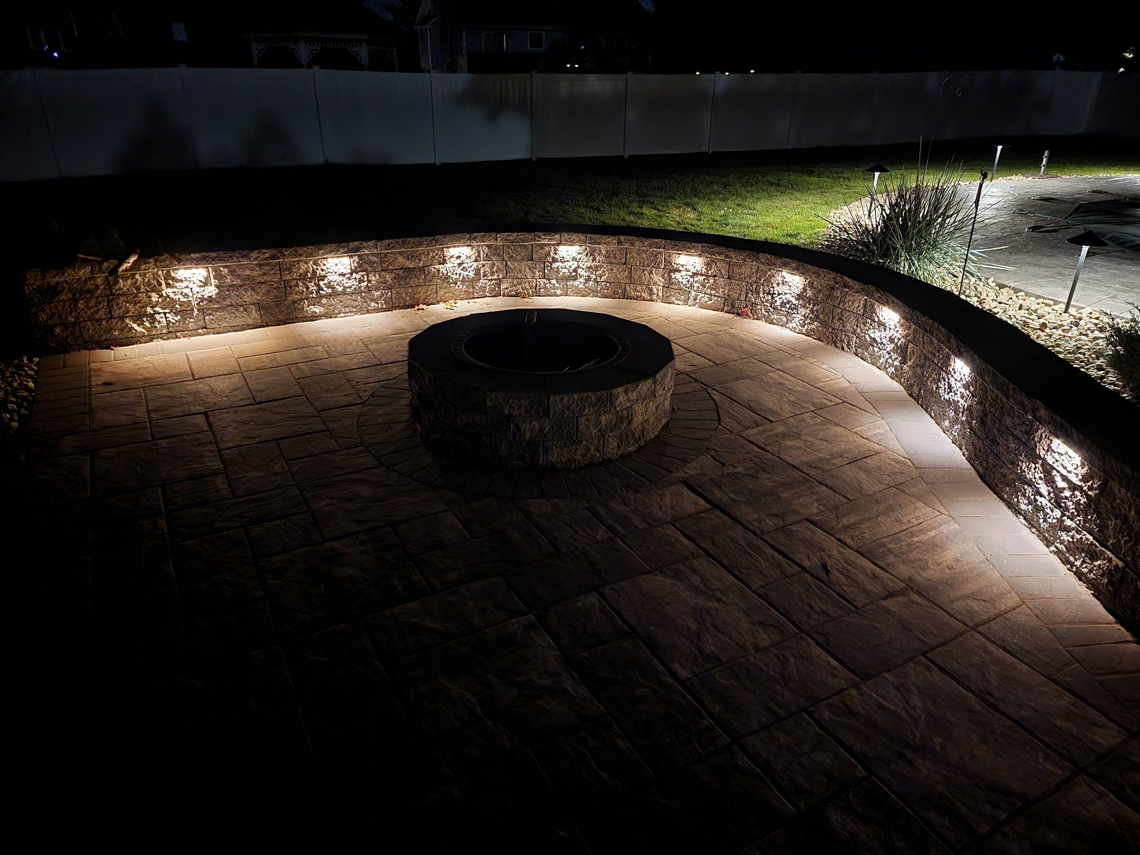 Fire pit patio with retaining wall cap lighting