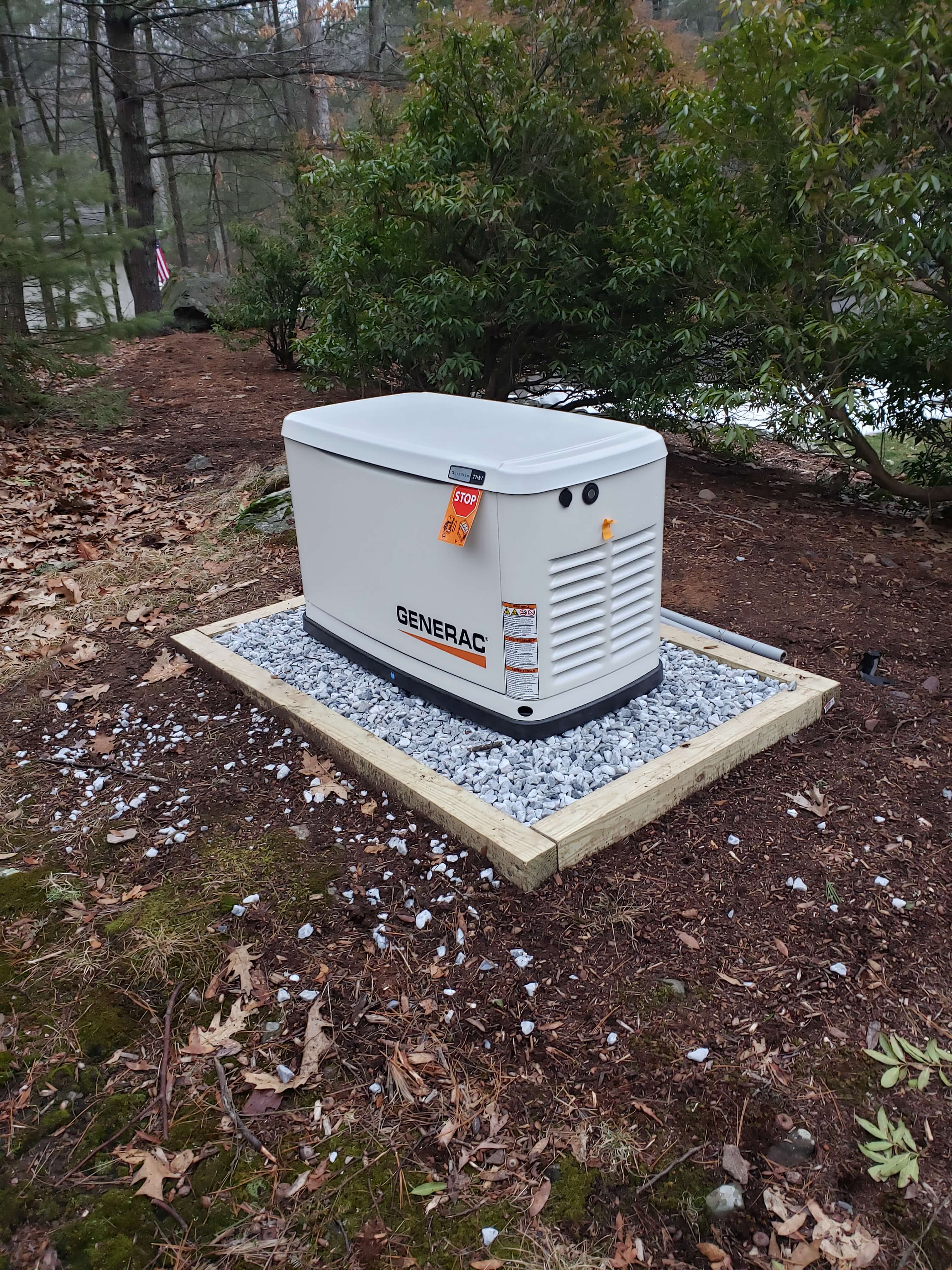Large commercial Generac generator installation in wooded backyard