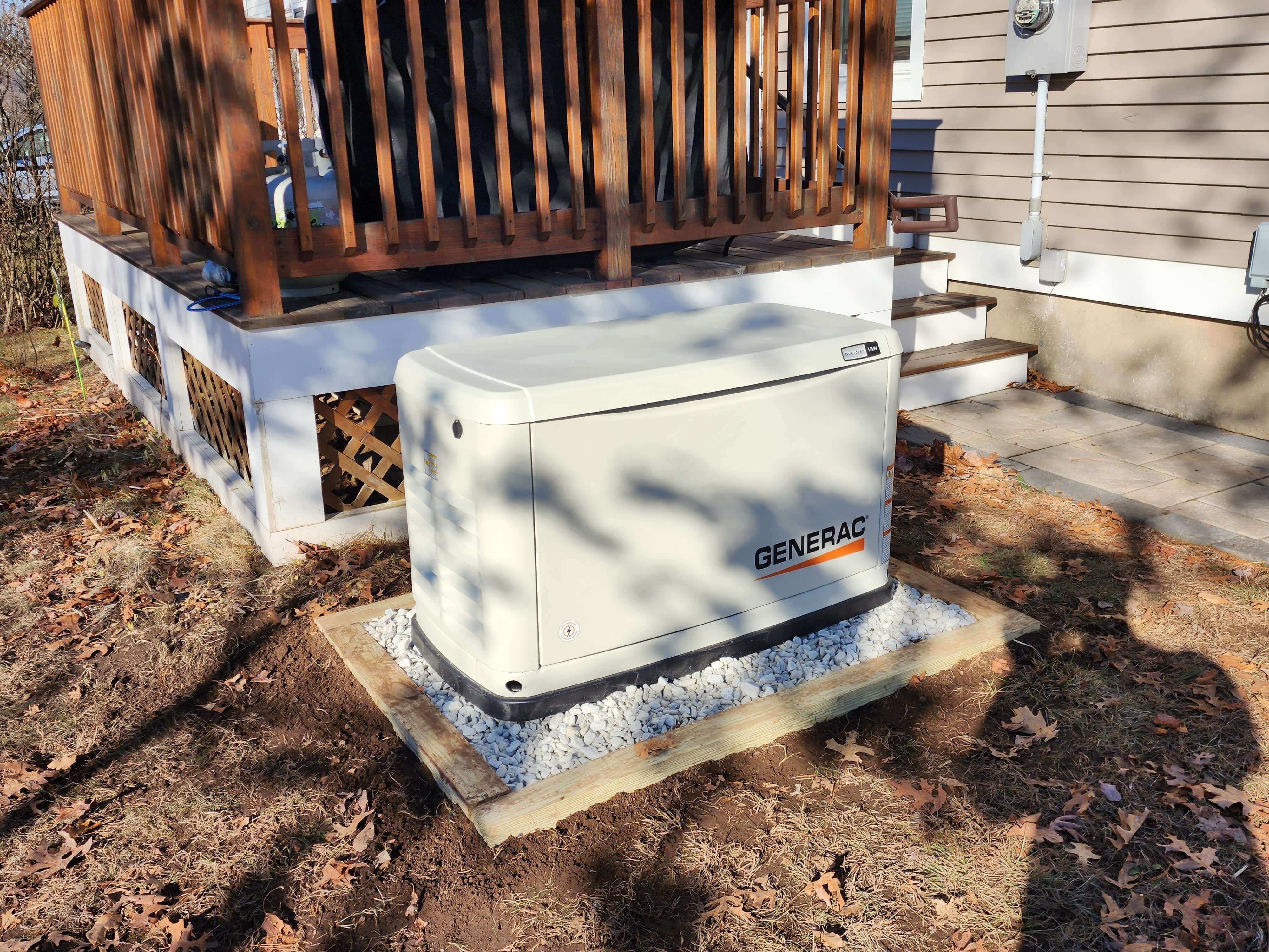 Generac generator on gravel pad next to home