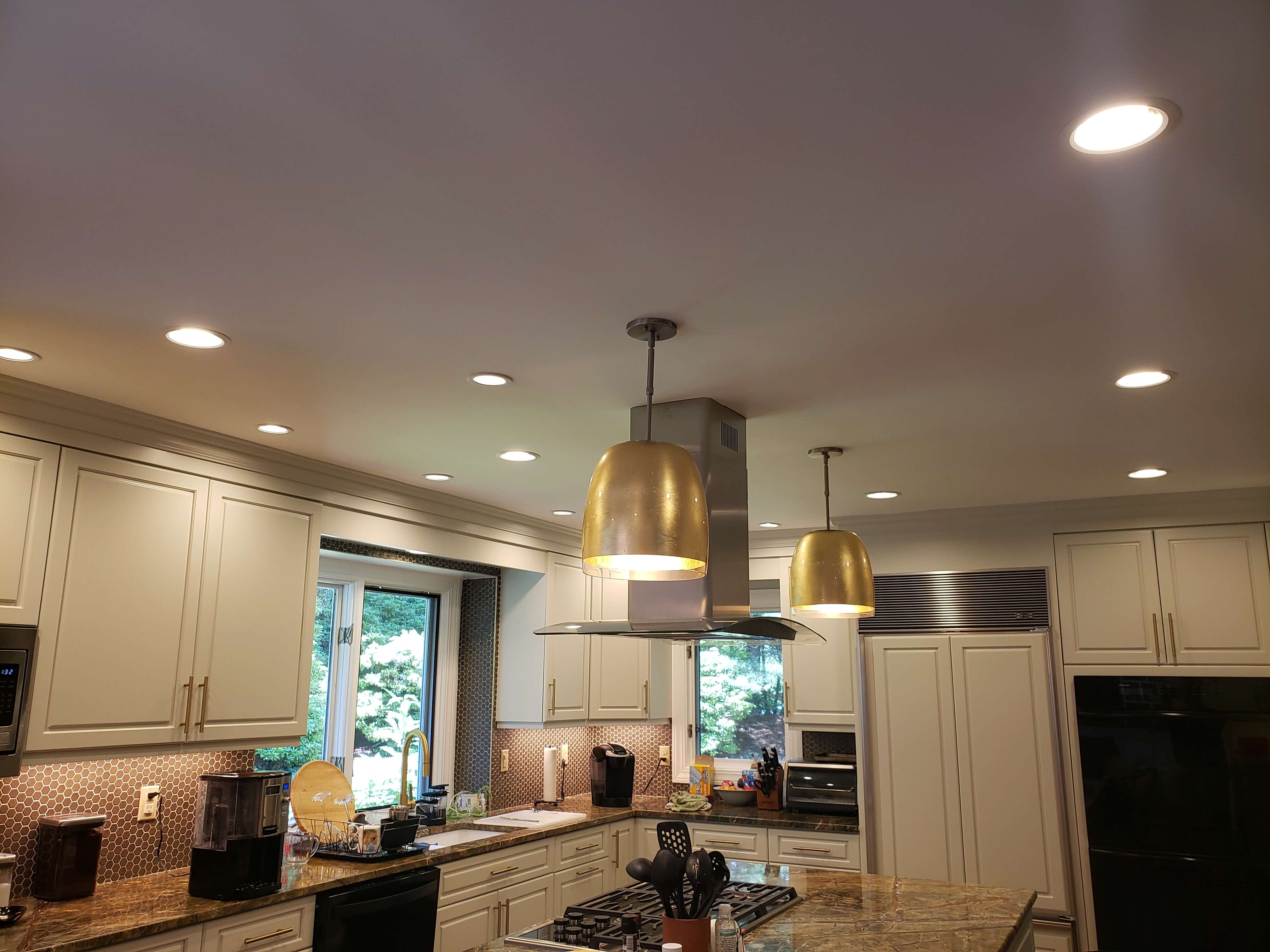 Kitchen island with gold pendant lights and recessed LED lighting