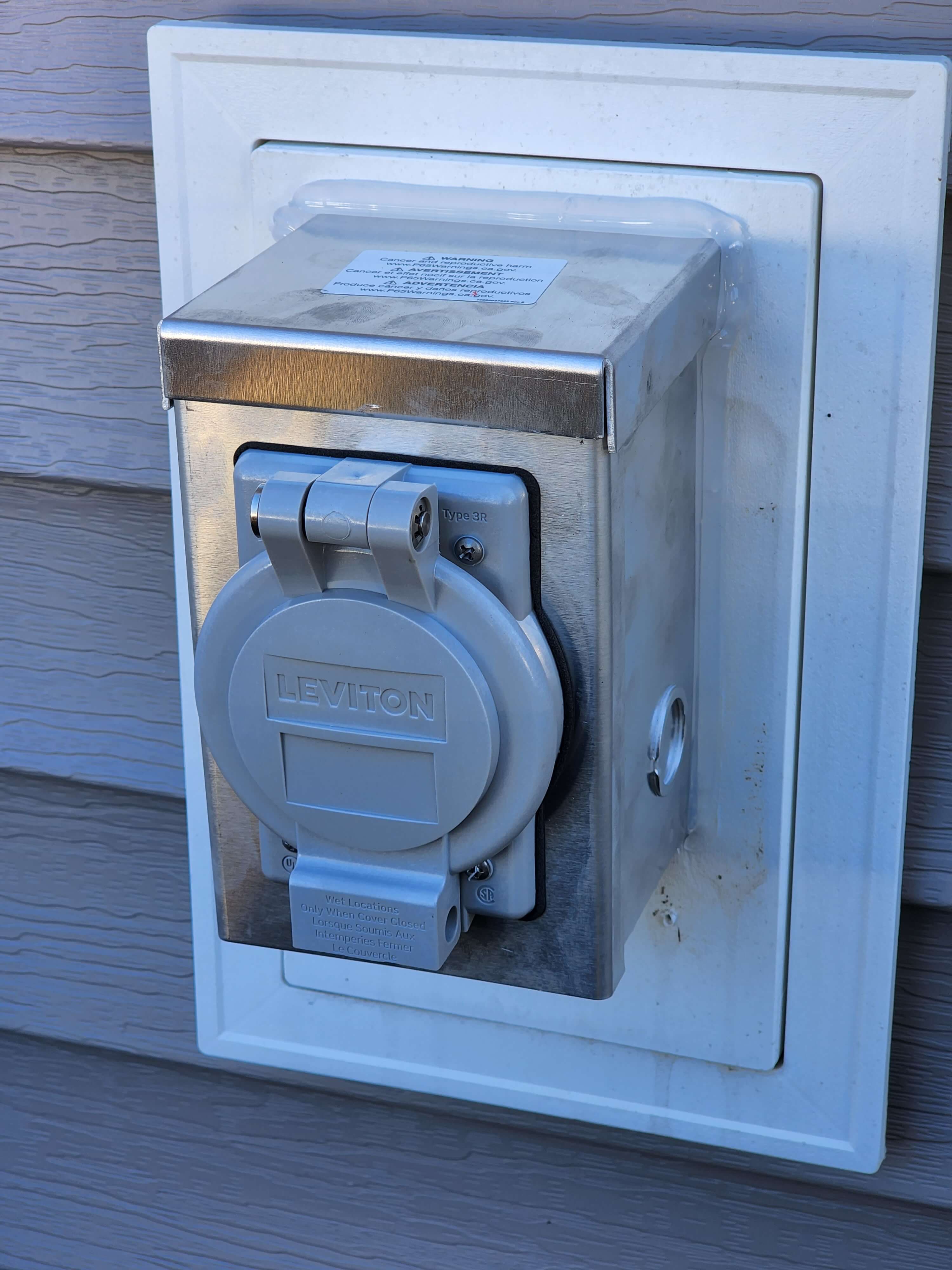 Leviton generator power inlet box on exterior wall with weatherproof cover
