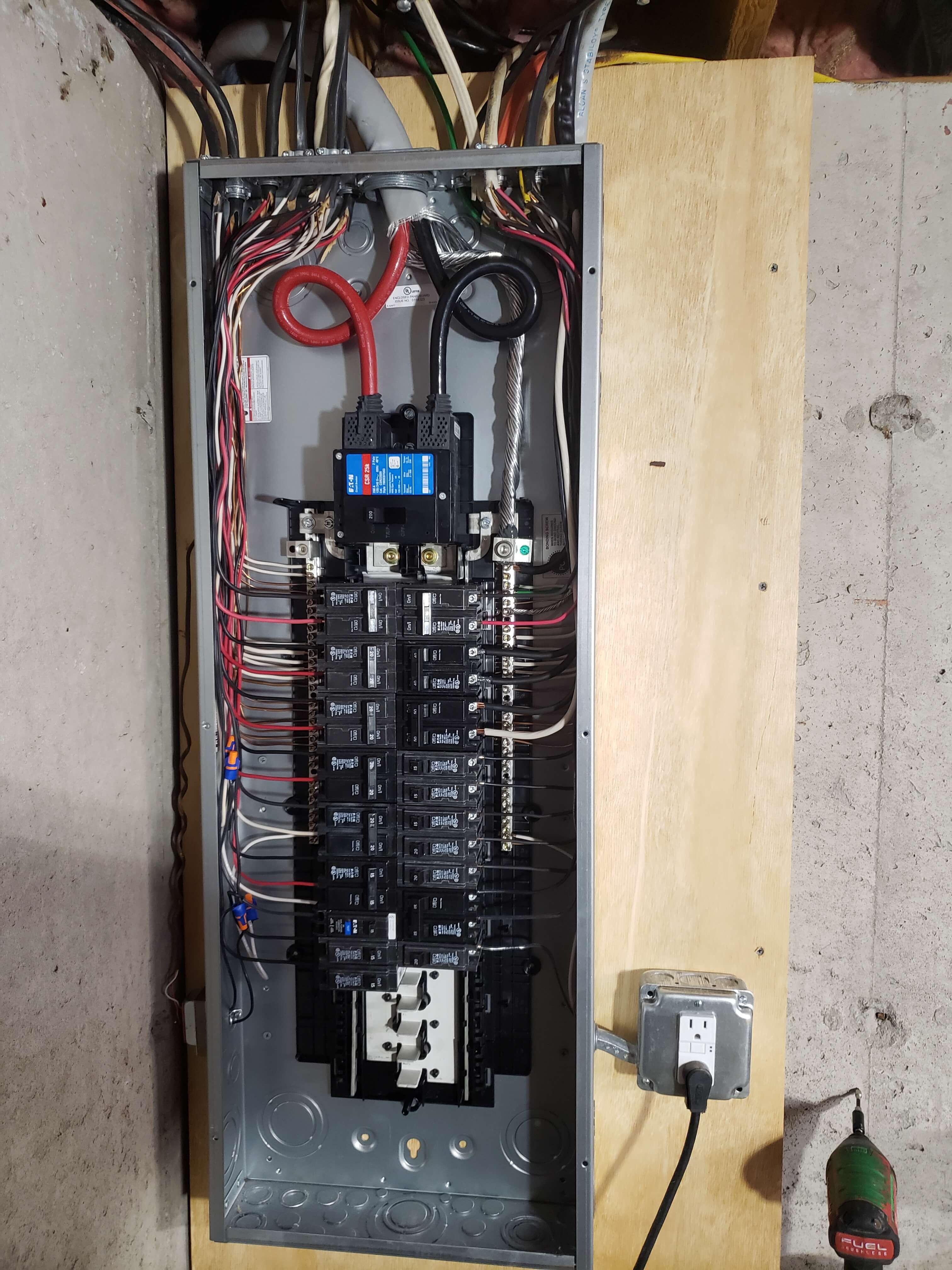 Eaton 200A panel with blue main breaker in basement installation