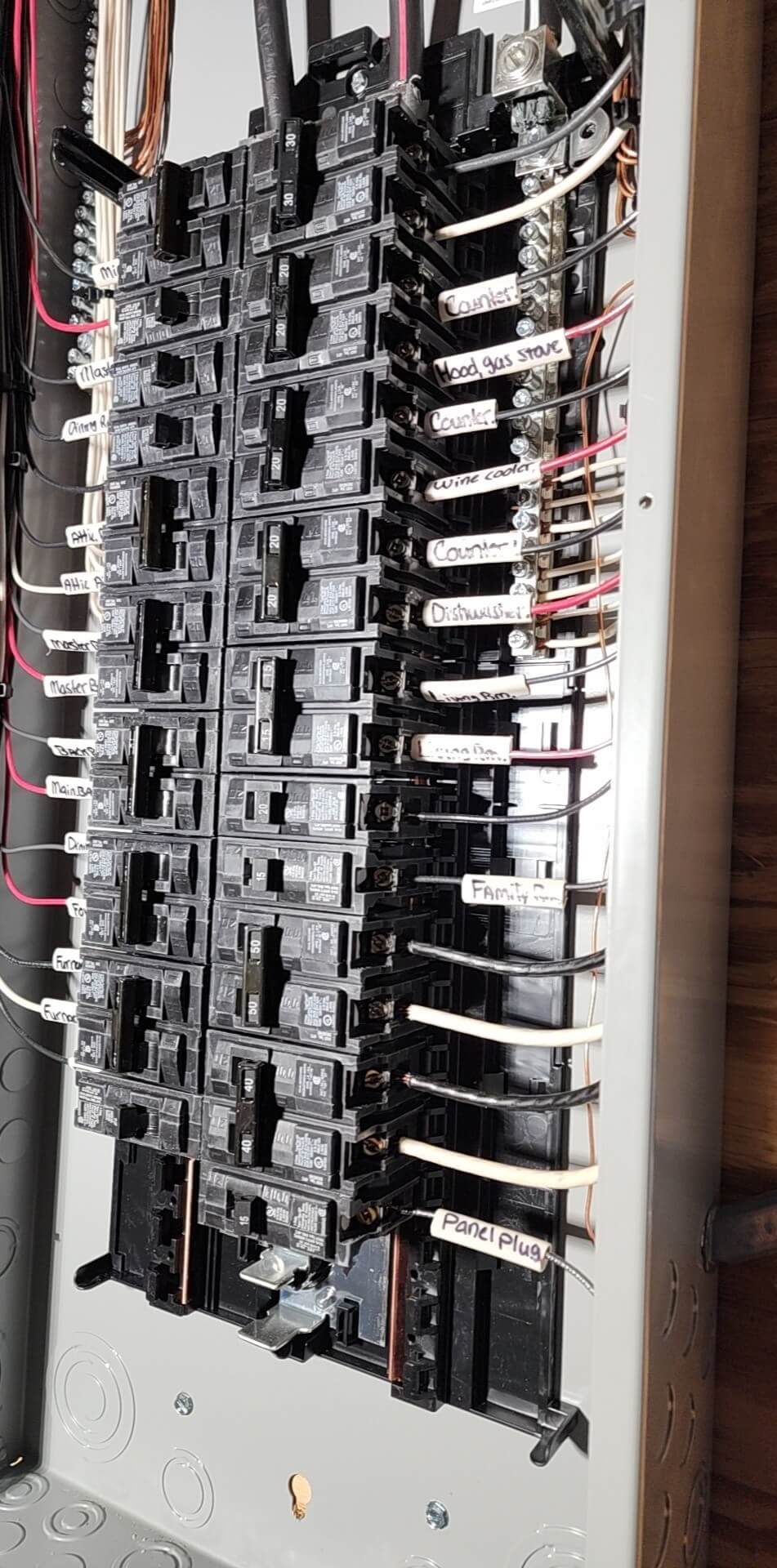 Electrical panel interior showing labeled breakers and organized wiring