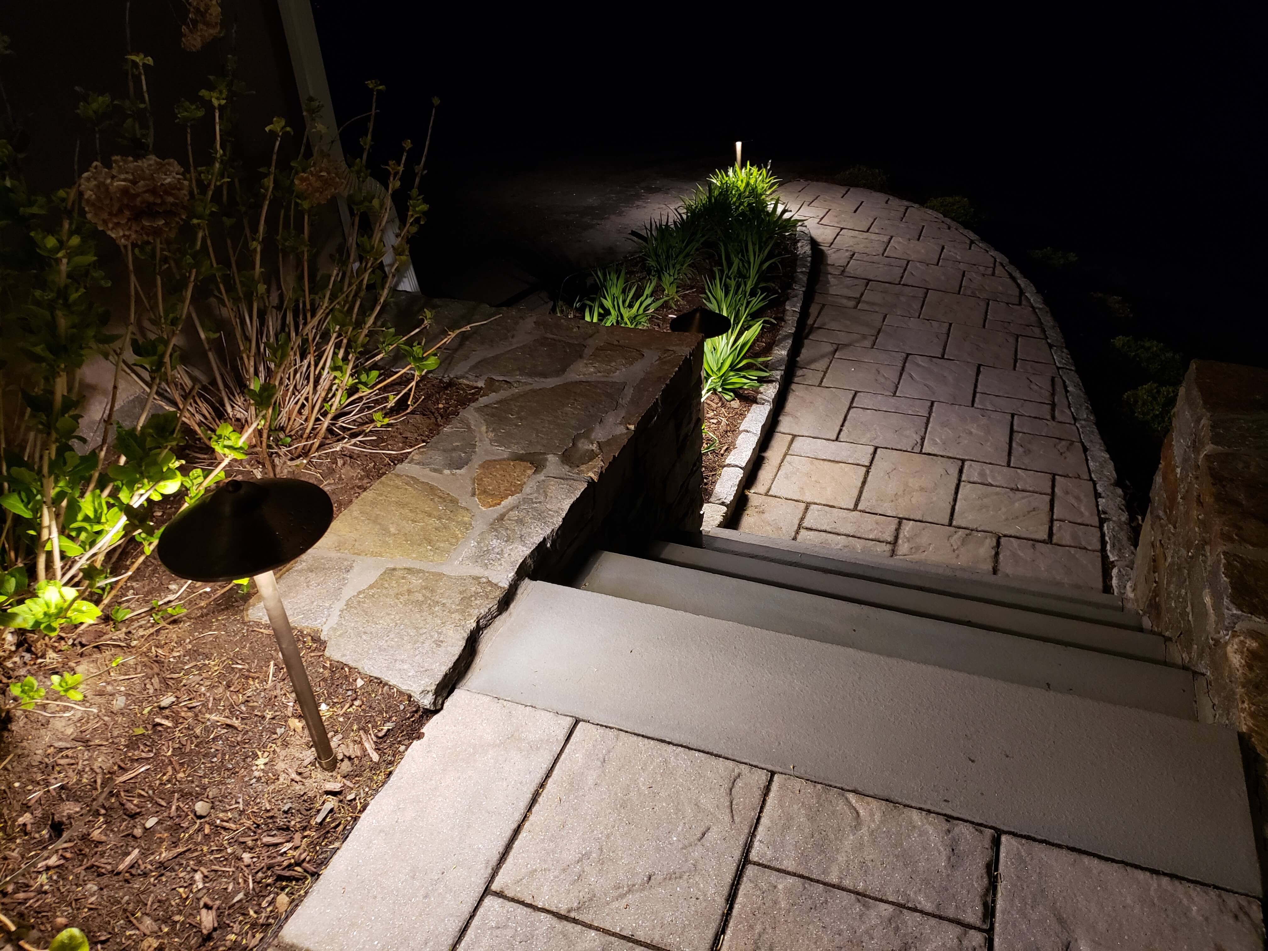 Close-up of pathway lighting along curved stone walkway