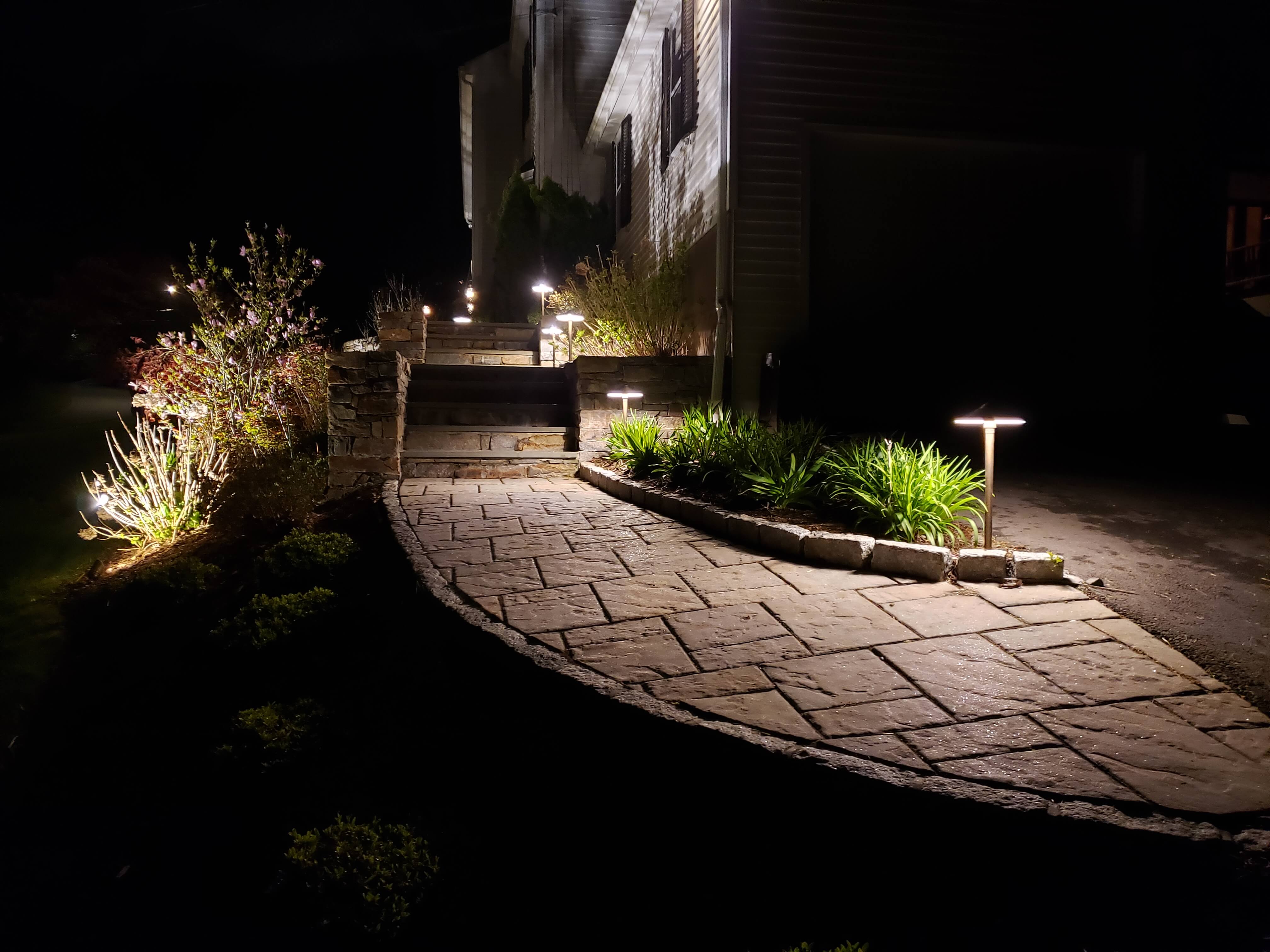 Curved stone pathway with mushroom path lights at night