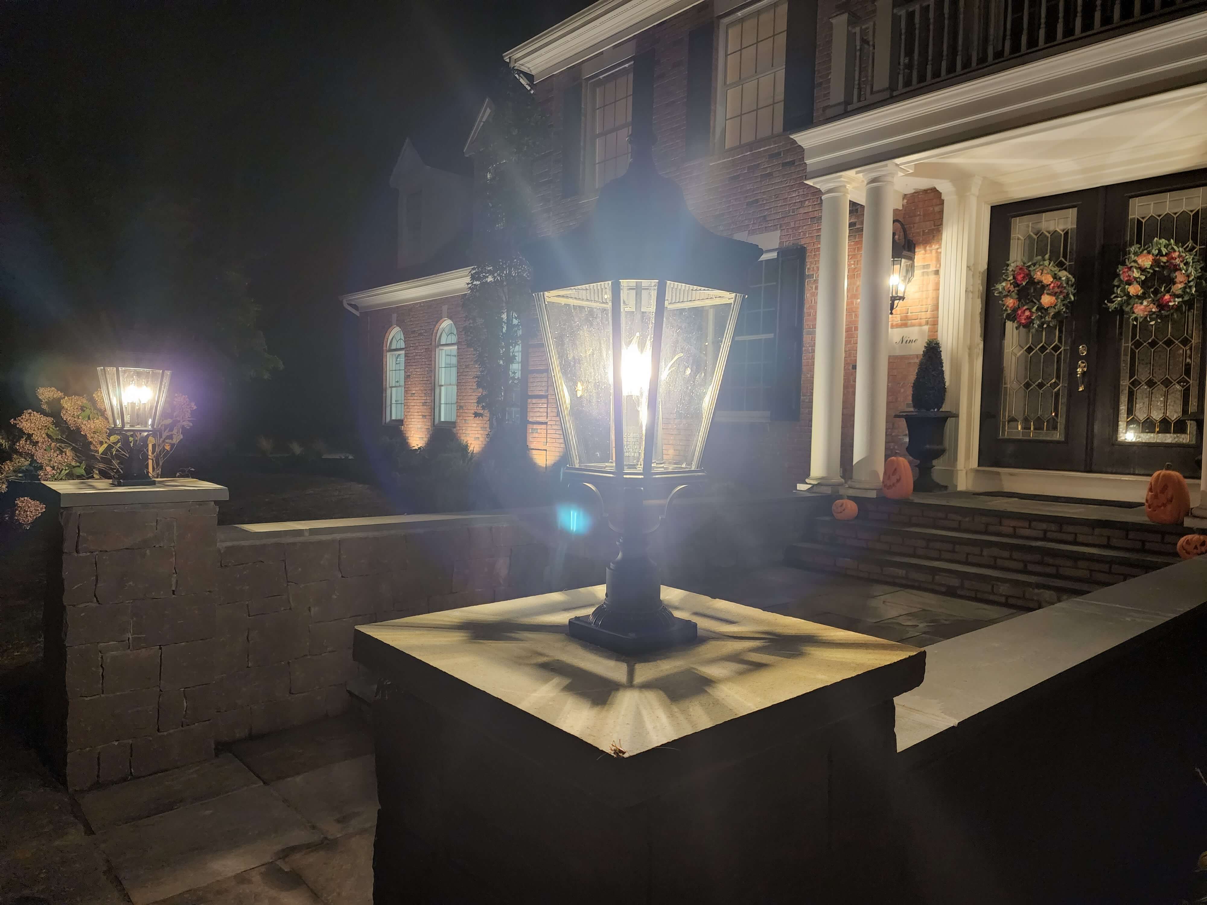 Elegant pillar post lights with gas-style lanterns at colonial home